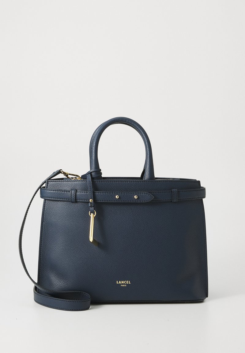 Navy pebbled leather handbag with dual top handles, removable shoulder strap, gold-tone hardware, and a clasp closure detail.