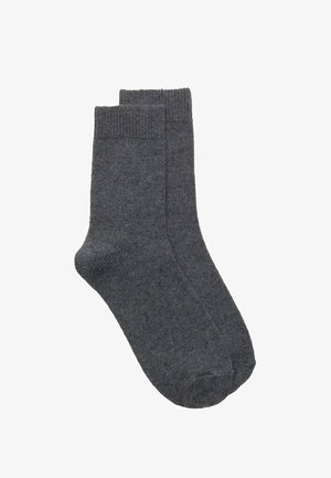 Sive gležnjarice iz mehkega blaga z rebrastimi robovi in gladko teksturo. Dizajn je preprost in enoten, brez vzorcev.