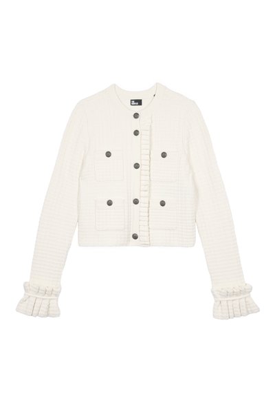 Veste courte blanche texturée avec un volant à l'avant, quatre poches plaquées et des boutons gris ; présente des poignets évasés avec des détails froncés.