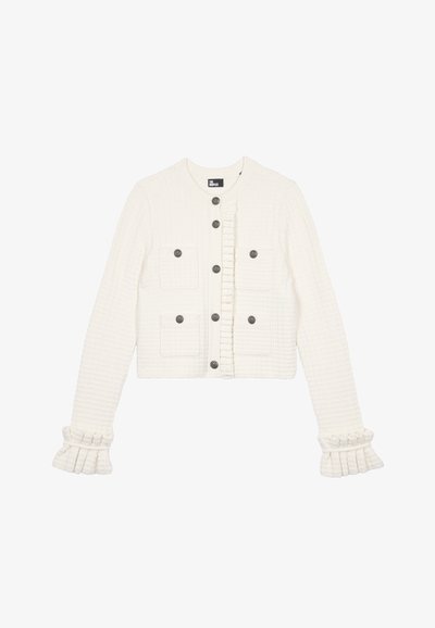 Biała, teksturowana krótka kurtka z falbaną z przodu, czterema naszytymi kieszeniami i szarymi guzikami; posiada dzwonowe mankiety z falbankami.