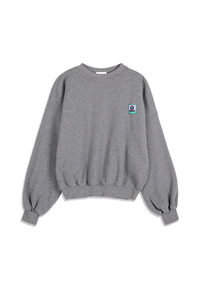 Sweat-shirt gris à manches longues avec poignets et ourlet élastiques, avec un petit patch coloré représentant un personnage sur la poitrine gauche.