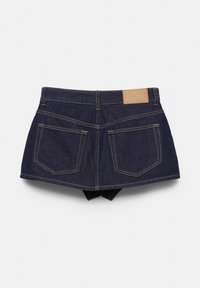 Mini-jupe en denim bleu foncé avec poches arrière, passants pour ceinture et un patch de marque en cuir beige sur la ceinture.