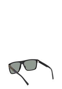 Lunettes de soleil noires avec verres verts, monture rectangulaire et finition mate. Présente des accents latéraux avec le logo de la marque sur la tige.