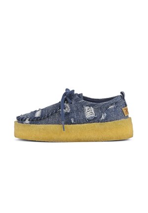 Denim shoes with visible distressing, blue color, and a yellow midsole. Features a lace-up design and stitching along the edges.