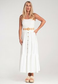 Biała, warstwowa sukienka maxi z ribbowaną górą, zapinana na guziki z plecionym paskiem. Połączona z beżowymi sandałami na platformie z teksturowanymi paskami.