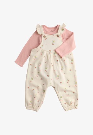 Crème clair avec des motifs floraux rouges et bleus, comportant des bretelles à volants et une sous-couche à manches longues rose. Matière en coton doux.