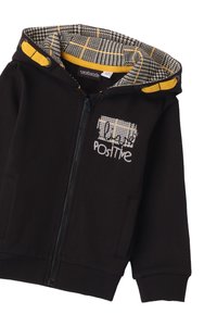Sudadera negra con cremallera y forro de estampado de cuadros, con acentos amarillos. Presenta el texto "Positive" en blanco en el frontal. Fabricada con tela suave.