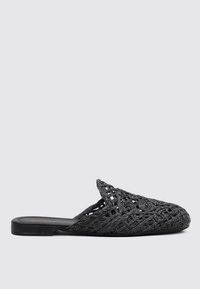 Mules noires à bout ouvert avec un design tissé, présentant une surface texturée et une semelle plate. Les détails incluent des motifs complexes et un profil épuré.