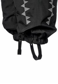 Svart tygmanschett med elastisk nederkant, grå triangulär reflexmönster och två svarta justerbara remmar eller öglor längst ner.