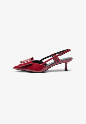 Czerwone lakierowane szpilki slingback z wąskim noskiem, wyróżniające się dużą kokardą i cienkim obcasem typu kitten heel. Pasek z czarnymi detalami.