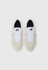 Nike SB tenisice od svijetlosmeđeg antilopa, s crnom tkaninom unutarnje obloge, bijelim vezicama i detaljima logotipa. Zaobljeni vrh i ravni gumeni potplat.