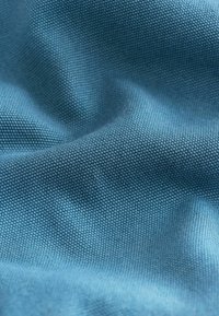 Gestructureerde blauwe stof met een fijne weef, die een zachte, gladde afwerking en subtiele glans toont, met elegante plooien.