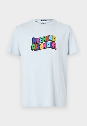Světle modré bavlněné tričko s vícebarevným potiskem "WEEKEND OFFENDER" umístěným na hrudi v tučných a hravých písmenech.