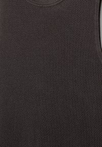 Débardeur sans manches gris foncé en tissu texturé, avec un col rond et une bordure côtelée le long des bords.