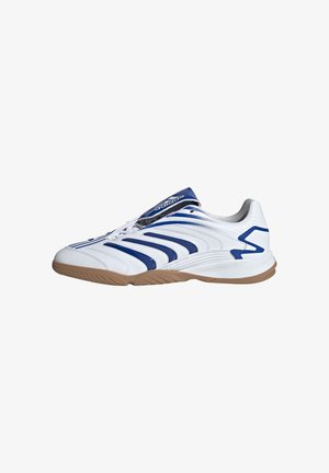 Scarpe sportive bianche con dettagli blu, con una tomaia texture, lacci e una suola in gomma di tipo gum. Design snodato per comfort e supporto.