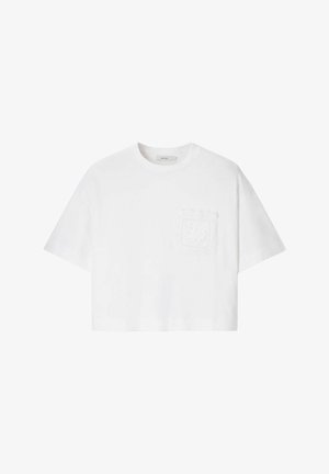 T-shirt court blanc à manches courtes avec un col rond et une poche brodée décorative sur la poitrine gauche.
