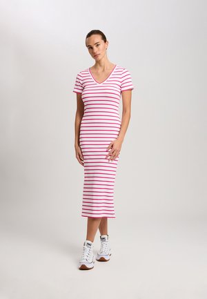 Gestreiftes Midikleid in Weiß und Pink, mit V-Ausschnitt und kurzen Ärmeln. Trägt dazu weiße High-Top-Sneaker.