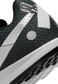 Czarny i szary but sportowy z cholewką wykonaną z teksturowanej tkaniny, odblaskowymi akcentami oraz białą gumową podeszwą z czarnymi detalami zapewniającymi przyczepność.