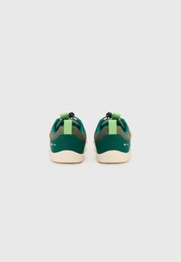 Zapatillas verdes y marrones con una parte superior texturizada, acentos en contraste y tiradores en el talón para facilitar ponerlas. Suela de goma.