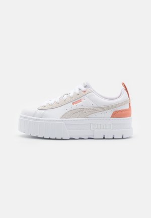 Białe sneakersy z teksturowaną beżową zamszową wstawką, podwyższoną podeszwą, dyskretnymi różowymi akcentami i klasycznym projektowaniem na sznurowadła.