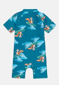 Maillot de bains à manches courtes pour enfants en bleu-vert, présentant un motif de renards de dessin animé sur des planches de surf, avec des feuilles vertes et des vagues bleues.