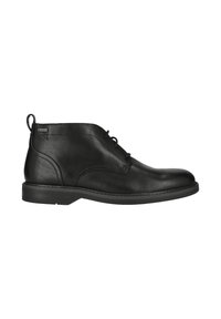 Bottine en cuir noir avec lacets, semelle robuste et étiquette Gore-Tex près du haut, sur fond blanc.