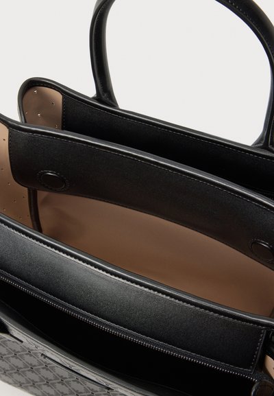 Černá taška přes rameno s dvojitými uchy, otevřeným vrškem odhalujícím béžovou vnitřní část a vnitřní přihrádkou se zipem.