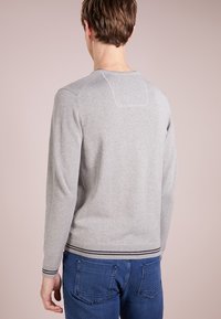 Grauer Pullover mit Rundhalsausschnitt und langen Ärmeln, der über eine subtile Struktur und einen gestreiften Saum verfügt. Die Rückansicht zeigt ein schlichtes Design mit klaren Linien.