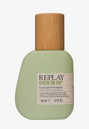 Light green, rounded bottle with a bamboo cap. Label displays "REPLAY GREEN ON ME," 30 ml Eau de Parfum, with eco-friendly notes.