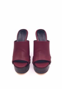 Pantofole in pelle bordeaux con design open toe, dotate di una piattaforma in sughero nero texturizzato e dettagli in metallo color oro.