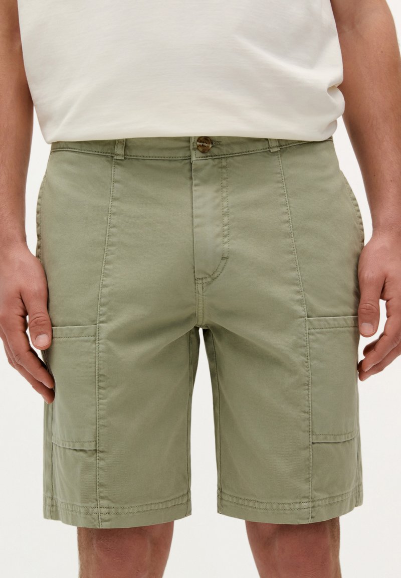 Groene katoenen shorts met een rechte snit, twee zijzakken en een sluiting met een voorknop. Kenmerkt zich door zichtbare stiksels en een gladde textuur.