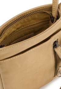 Sac à main en cuir beige avec un compartiment principal zippé, une poche intérieure et une texture lisse avec des détails cousus.
