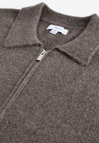 Bruine wollen zip-up jas met een kraag en zilveren ritsdetails. Gelaagde stof met een fijne weefpatroon, voorzien van een merketiket.