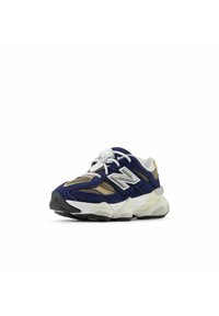 Sneaker New Balance blu navy e beige con lacci bianchi, suola bianca e grigia, e parte superiore in mesh e suede, inclinato a sinistra su sfondo bianco.