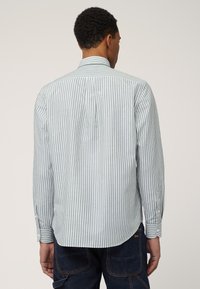 Chemise à manches longues, à boutons, avec des rayures verticales vertes et blanches, un col classique et une plisse dans le dos pour plus de liberté de mouvement.