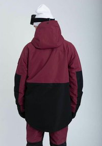 Burgunder- og sort isoleret jakke med hætte, der har et strømlinet design og kontrasterende farver, lavet af vejrbestandigt materiale.