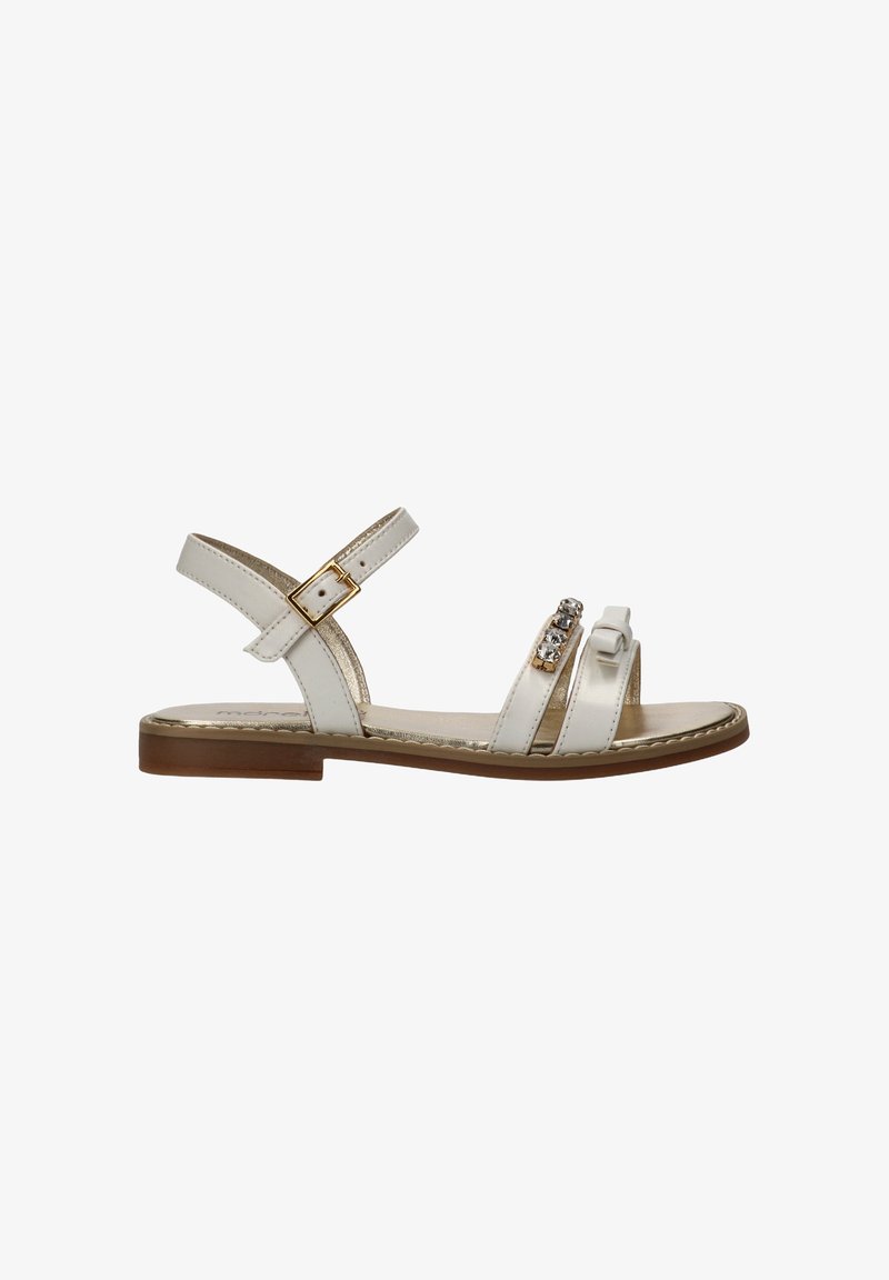 Witte platte sandaal met enkelriem en gesp, en twee voorste bandjes, waarvan één versierd met strasssteentjes en een strikdetail, bruine zool.