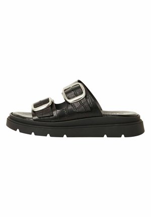 Infradito neri con suola spessa, due ampie cinghie testurizzate e grandi fibbie in argento su sfondo bianco.