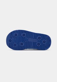 Zila gumijas zole ar teksturētiem rakstiem, apaļiem saķeres punktiem un zīmola logotipu. Rievotā virsma nodrošina saķeri un elastību.