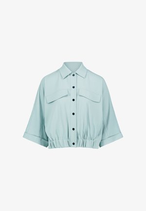 Svetlomodrá krátka košeľa s krátkymi rukávmi, čiernymi gombíkmi vpredu, dvoma náprsnými vreckami s klapkami a elastickým pásom.