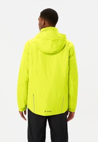 Waterdichte gele jas met een capuchon, elastische manchetten en reflecterende accenten. Voorzien van zijzakken en een logo aan de onderkant.