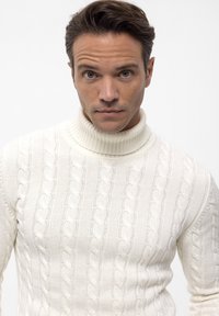 Weißer Pullover mit Kabelstrick und Rollkragen aus Wolle. Er verfügt über einen gerippten Kragen und ein strukturiertes Muster mit erhöhten, gedrehten Kabeln.