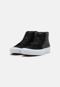 Sneaker alte nere realizzate in suede e tela, con suola in gomma bianca, lacci neri e dettagli laterali texturizzati.