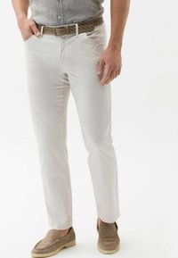 Witte katoenen chino's met een rechte pijpzool, gecombineerd met een gevlochten tan leren riem en lichtbruine suède instappers.