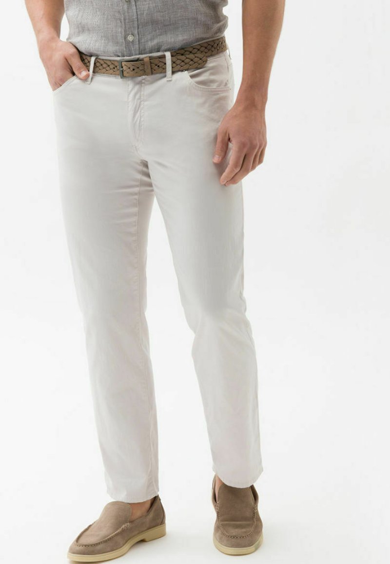 Witte katoenen chino's met een rechte pijpzool, gecombineerd met een gevlochten tan leren riem en lichtbruine suède instappers.