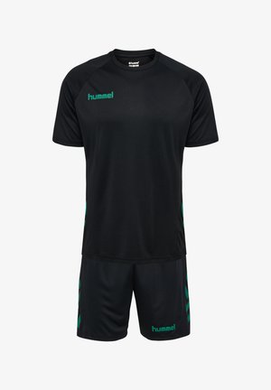 Zwarte sportjersey en shorts van lichte stof. Kenmerkt groene accenten en het woord "hummel" in groen op zowel de bovenkant als de onderkant.