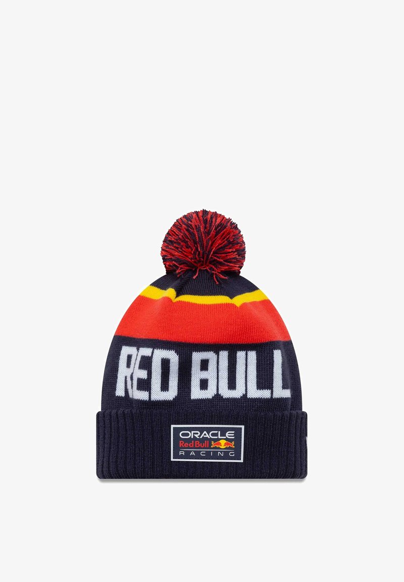 Czapka dzianinowa z granatowym tłem, czerwono-żółtymi paskami oraz czerwonym pomponem na górze. Logo "RED BULL" oraz metka "Oracle Red Bull Racing" na mankiecie.