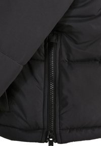 Sort isoleret jakke med markant lynlåslukning, glat stoftekstur og quiltet design langs kroppen.