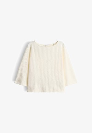 Cremefarbener, gerippter Strickpullover mit weiten Ärmeln und rundem Ausschnitt, flach auf weißem Hintergrund präsentiert.