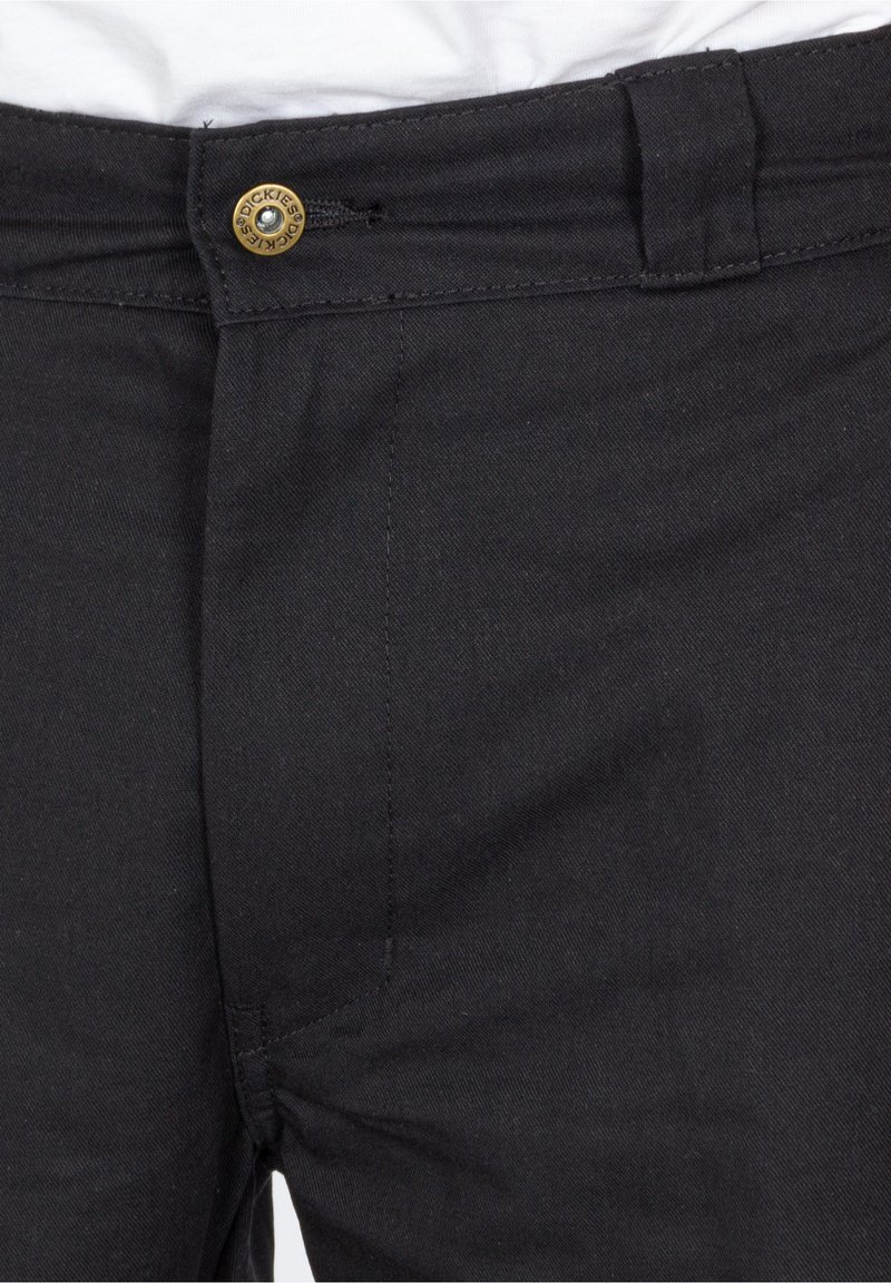 Schwarze Baumwollhosen mit Knopfverschluss, Gürtelschlaufen und glatter Textur, flachen vorderen Taschen und minimalem Nähdetail.